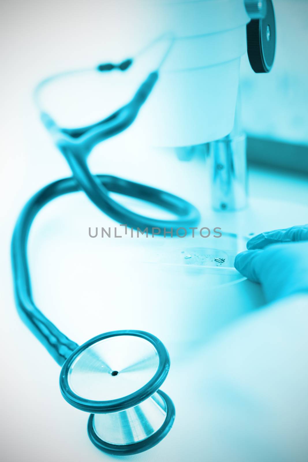 Blue stethoscope against doctor using microscope in laboratory