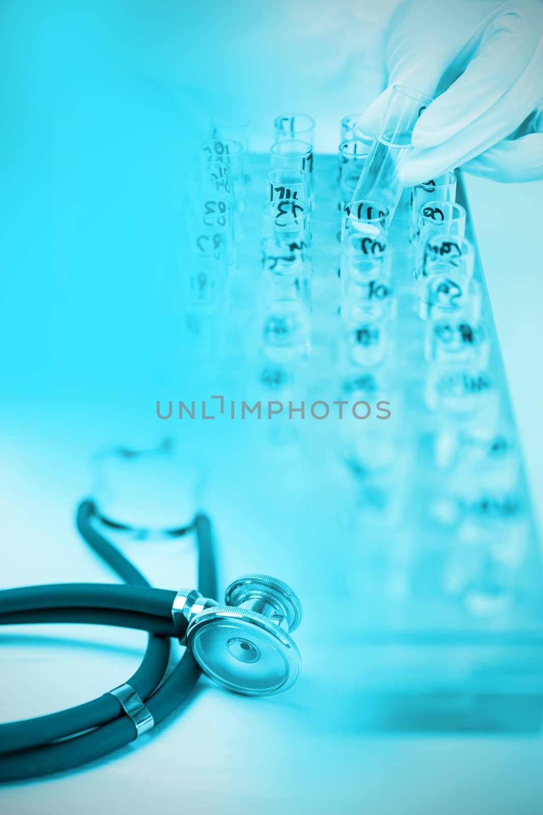 Stethoscope on desk against doctor checking a test tube
