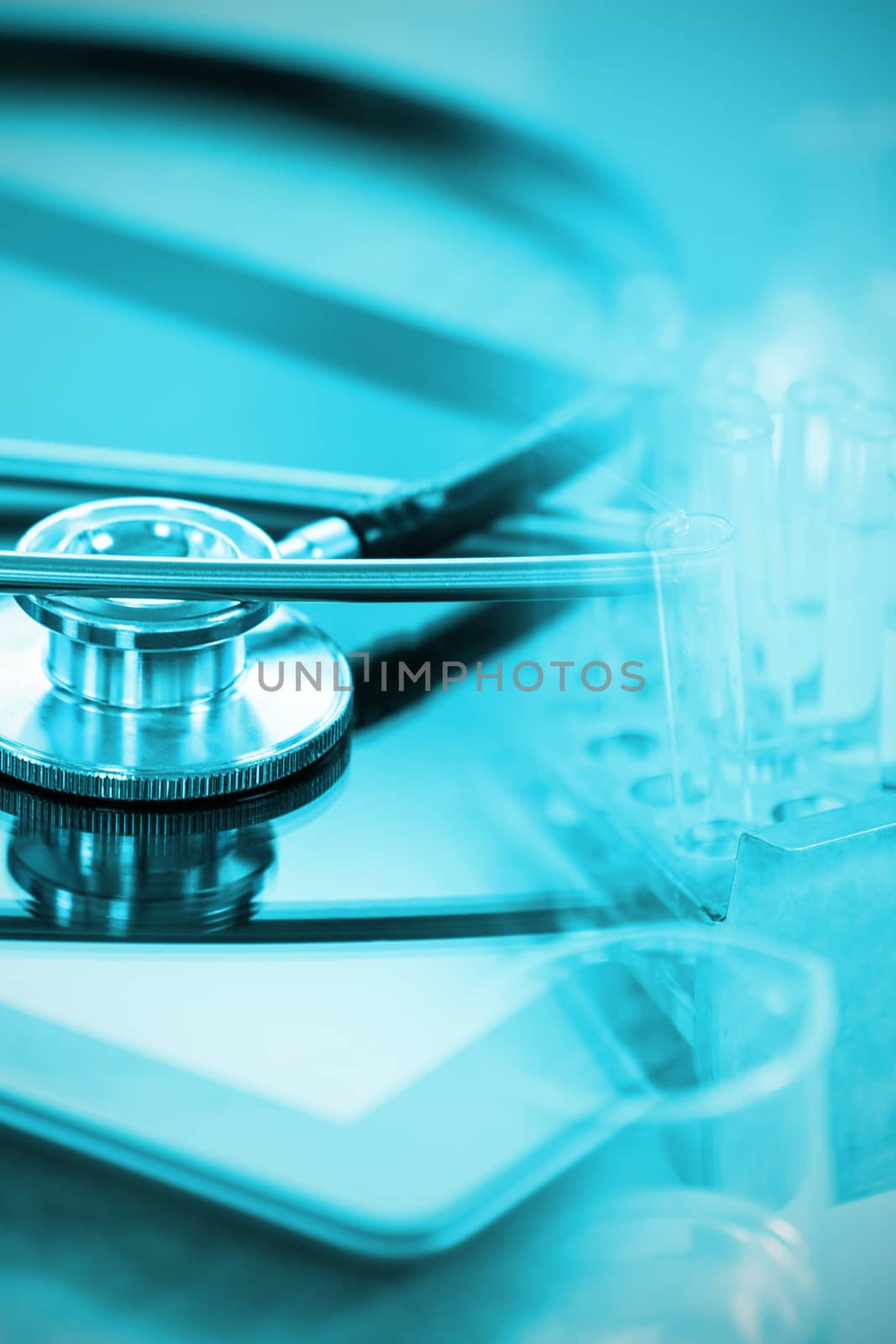 Stethoscope on digital tablet against doctor experimenting in laboratory