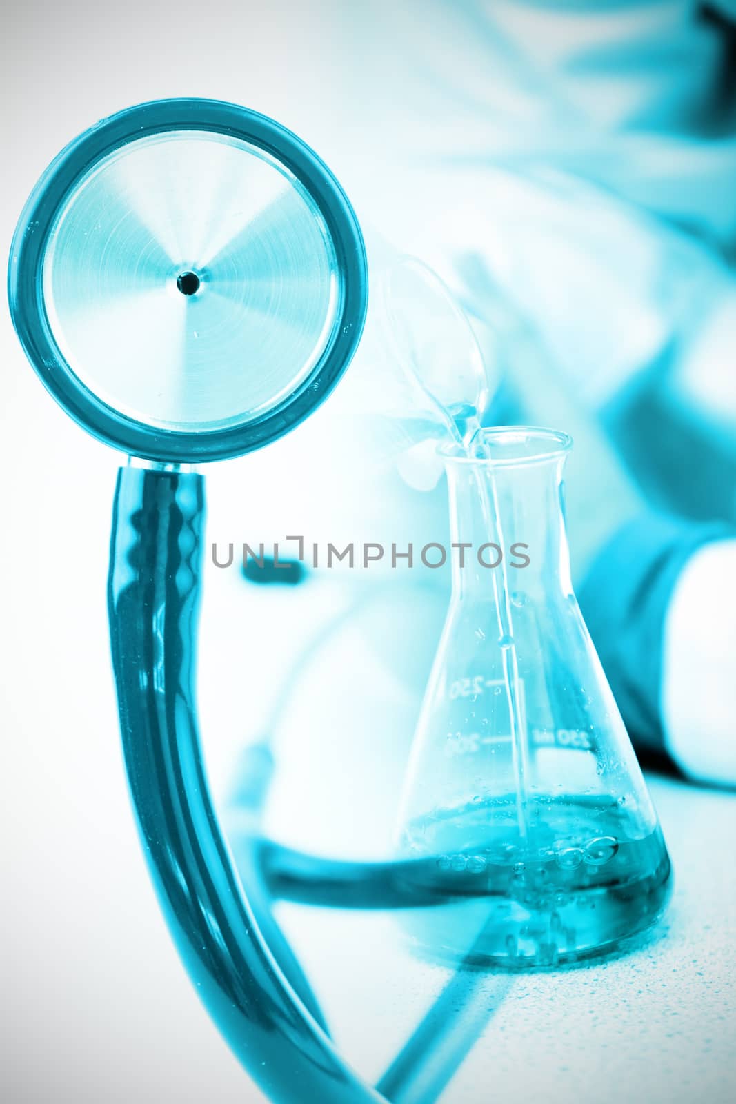 Part of the blue stethoscope against male chemist pouring a blue liquid
