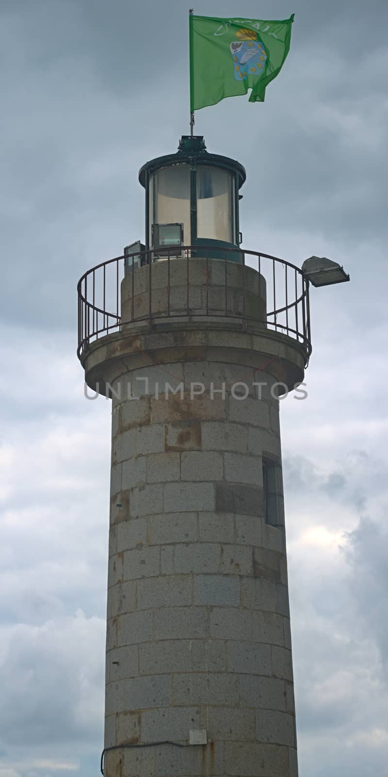 Stone lighthouse with green brittany flag at Cancale, France by sheriffkule