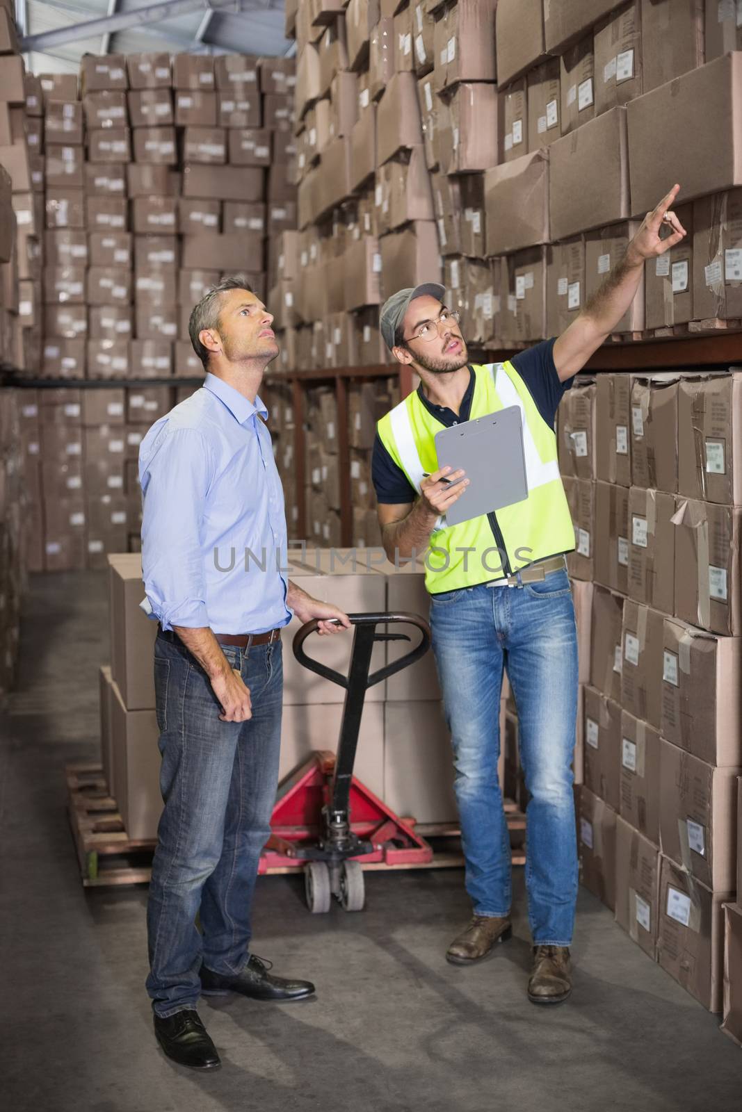 Warehouse manager talking with worker by Wavebreakmedia