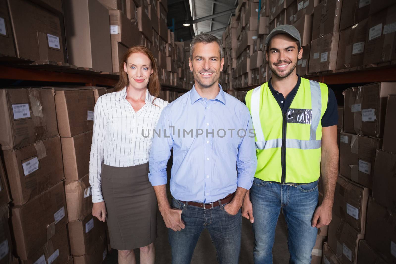 Warehouse team smiling at camera in a large warehouse