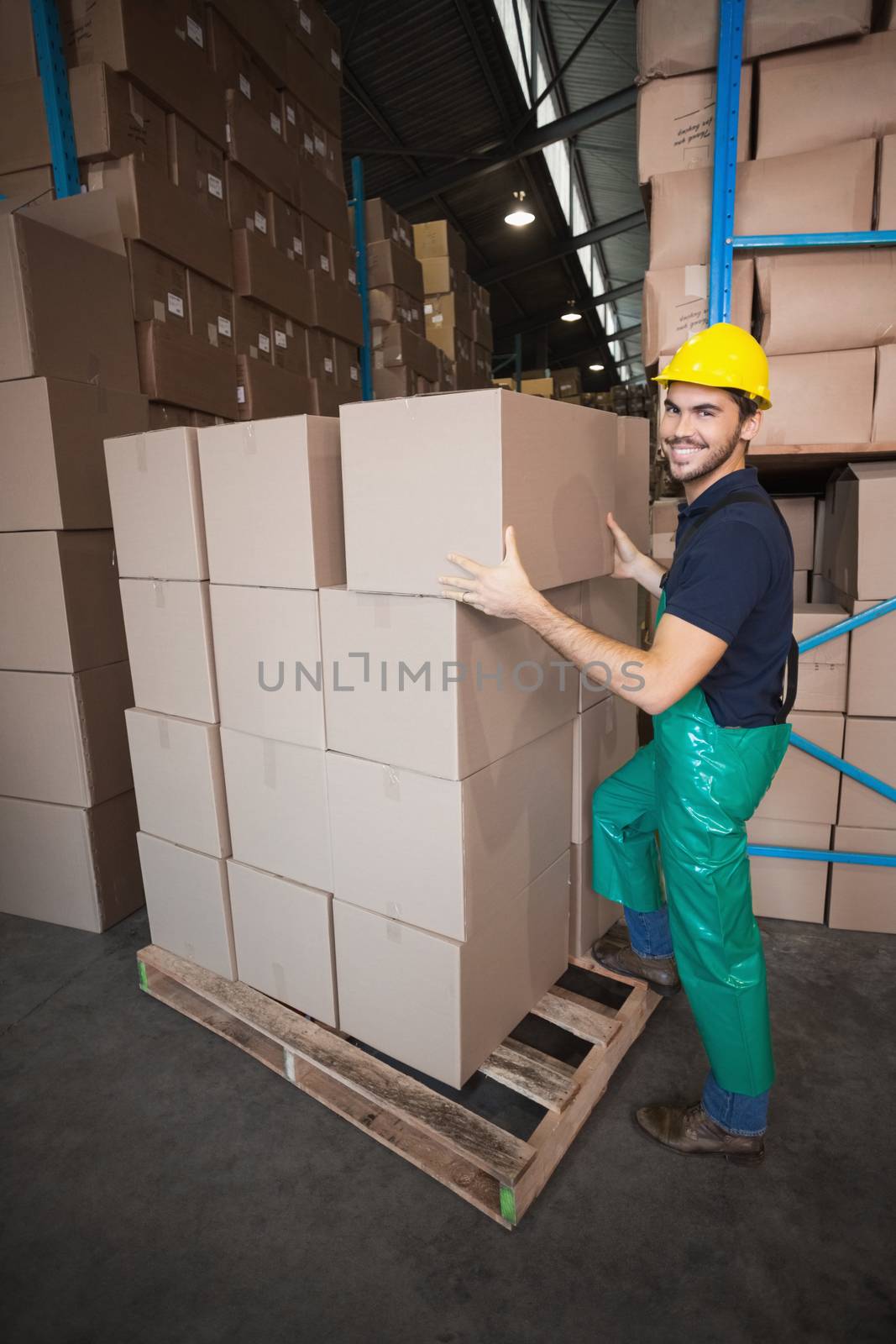 Warehouse worker loading up a pallet in a large warehouse