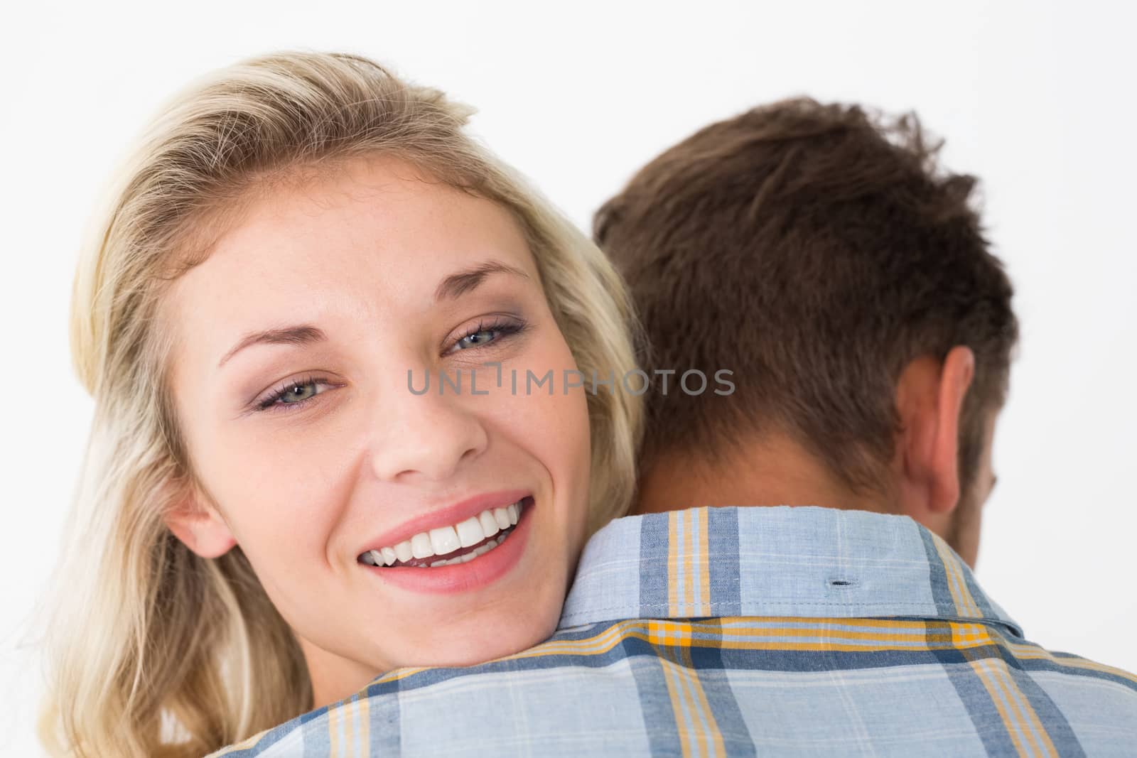 Close up of happy young couple embracing over white background