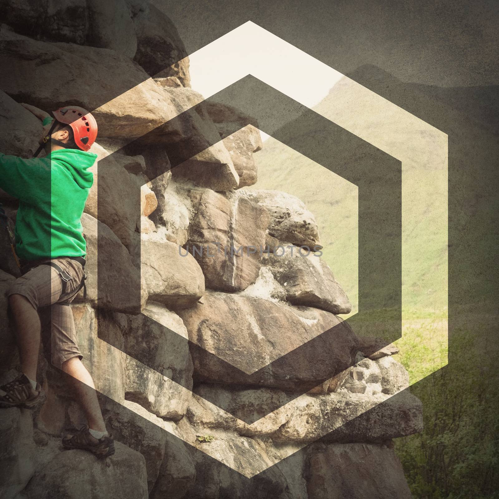 Focused man climbing a large rock face with mountains in the background