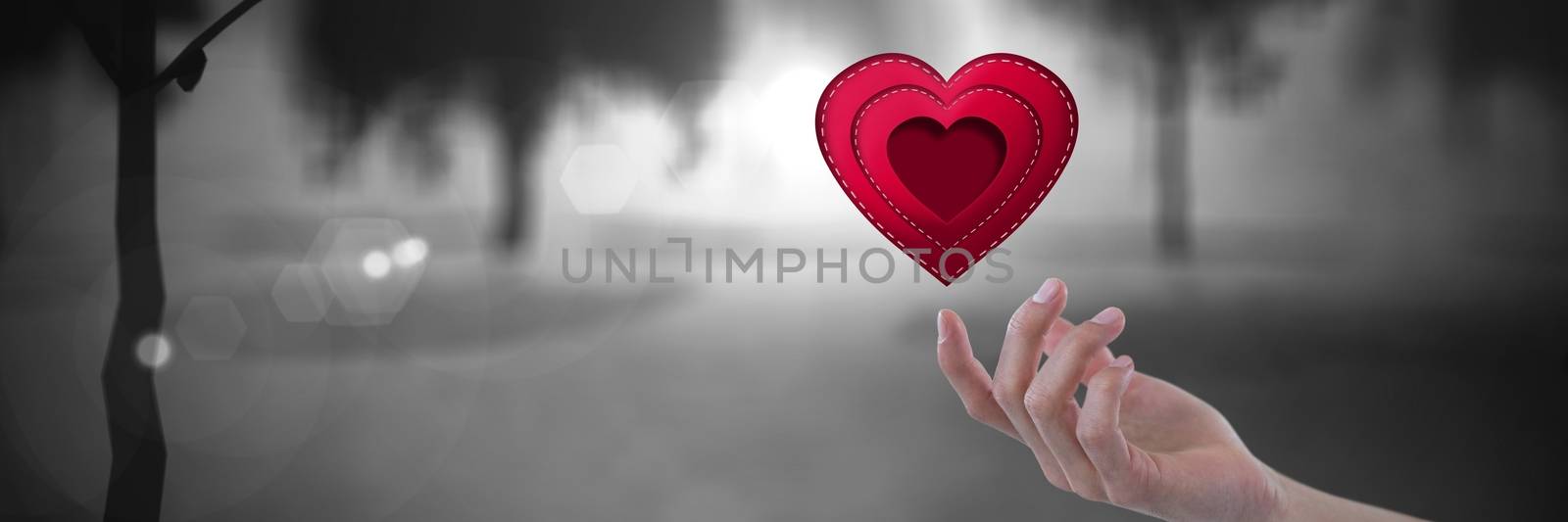 open hand touching a stitched heart with romantic mysterious trees by Wavebreakmedia