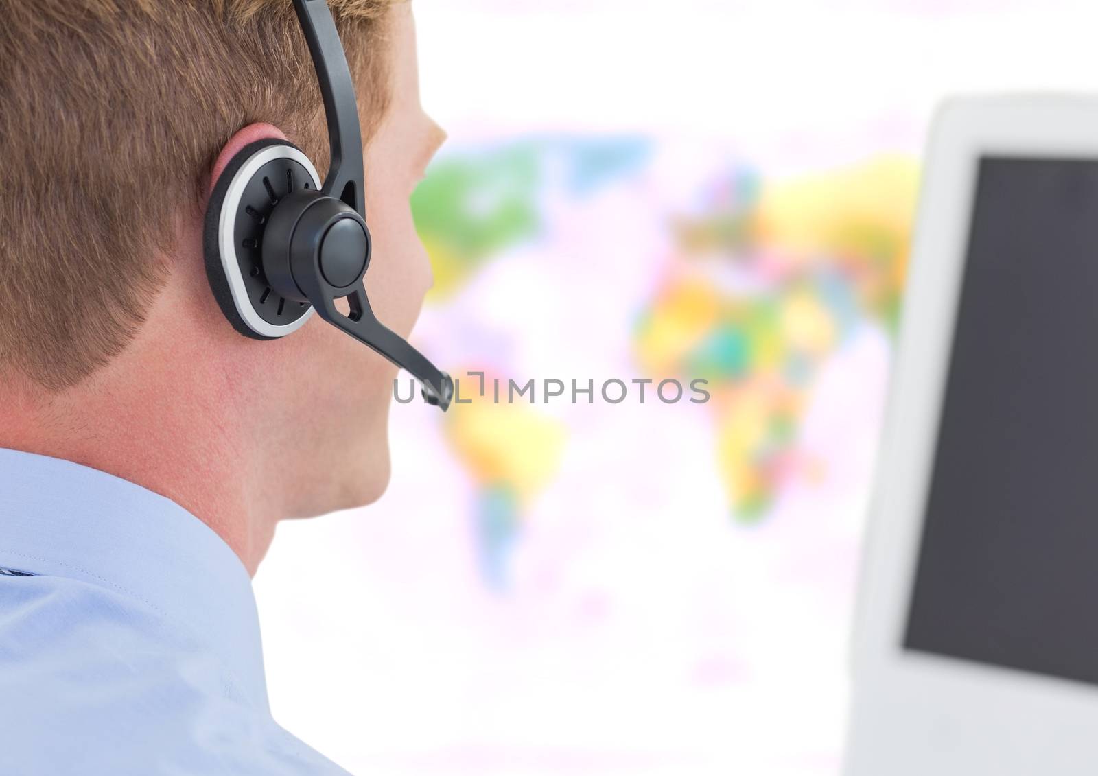 Travel agent man wearing headset in front of world map by Wavebreakmedia
