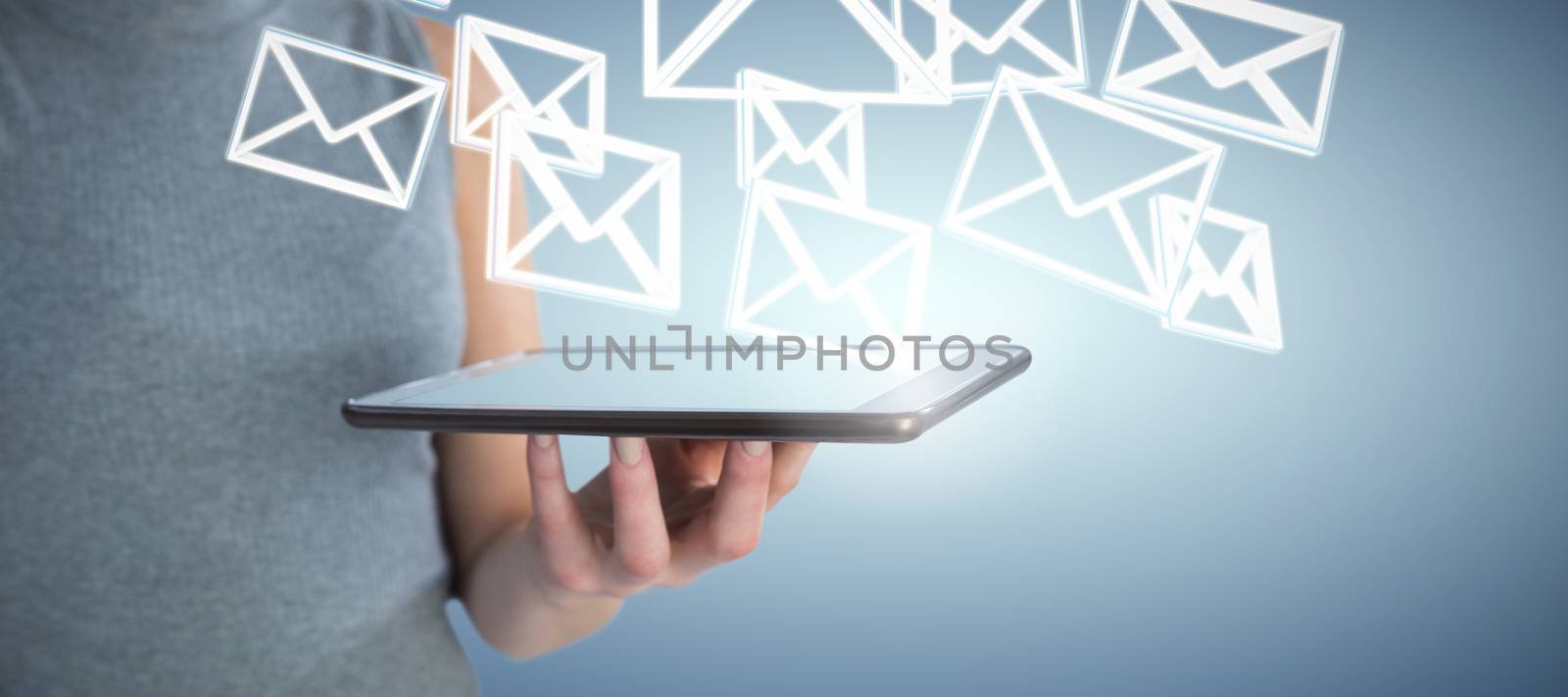 Mid section of businesswoman holding tablet computer against abstract blue background