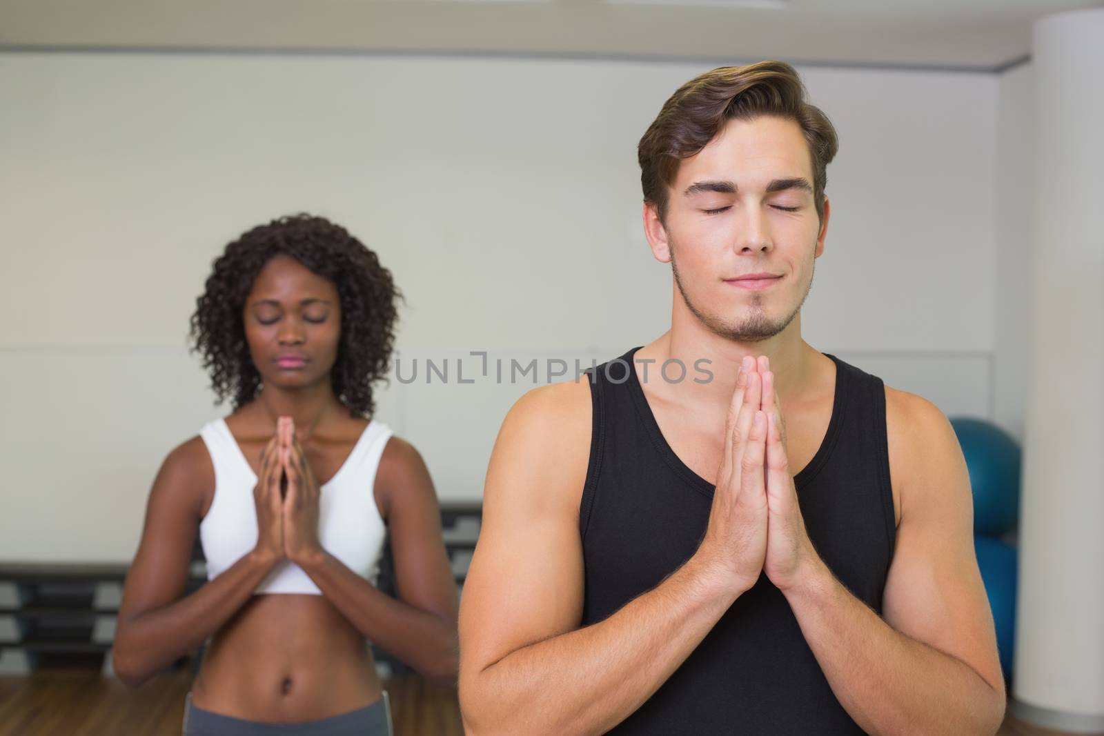 Fit couple standing with hands together at the gym