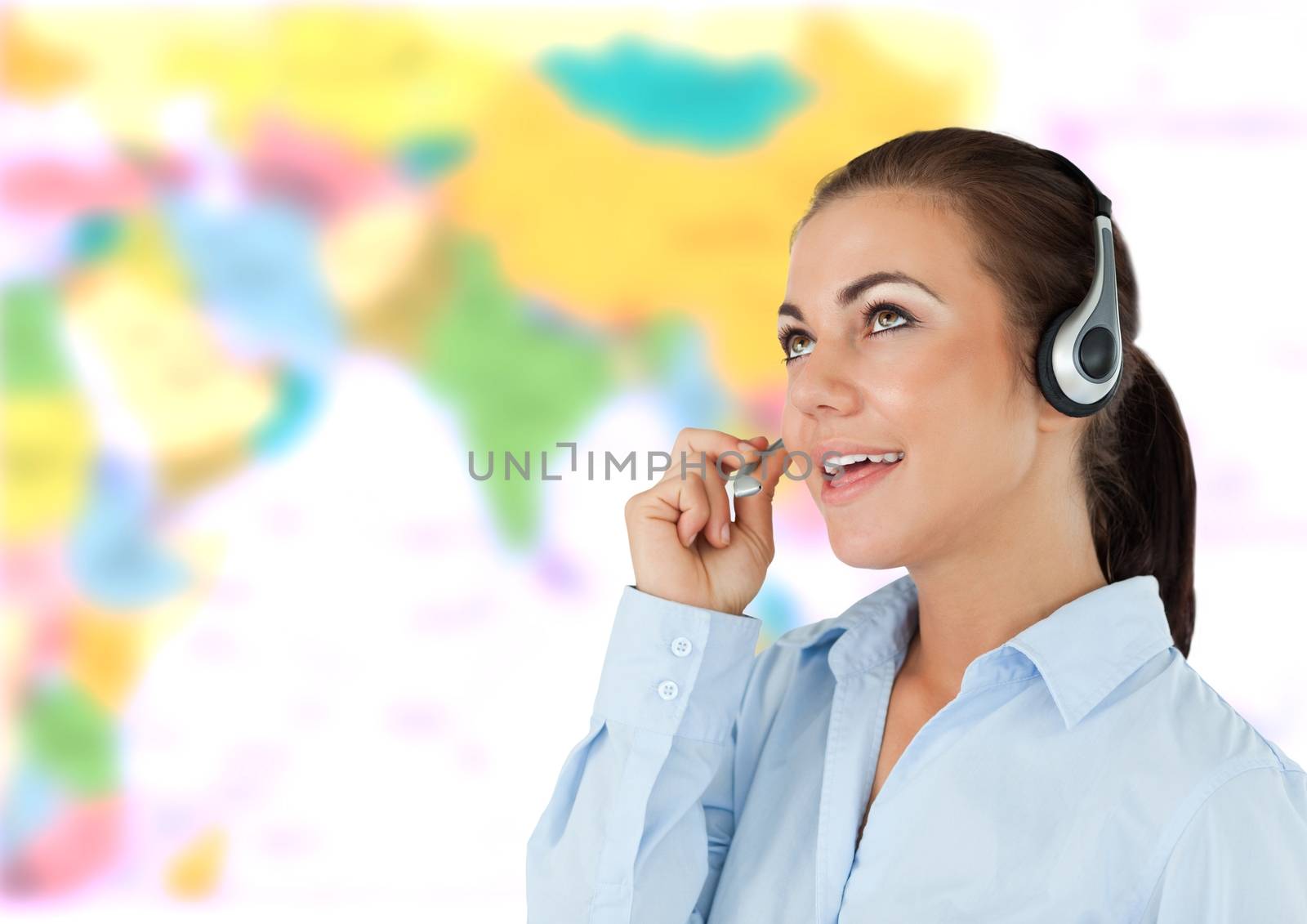 Travel agent woman wearing headset in front of world map by Wavebreakmedia