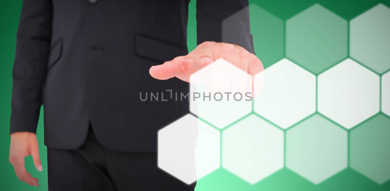 Businessman pointing with finger against abstract green background