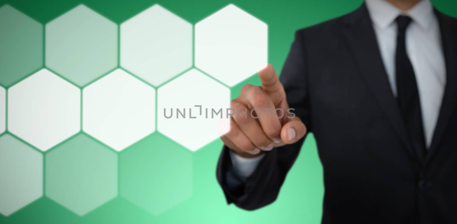 Mid section of businessman with pointing gesture against abstract green background