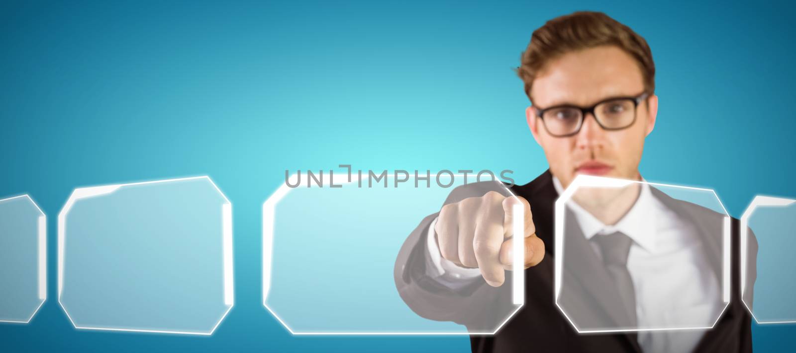 Young serious businessman pointing at camera against abstract blue background