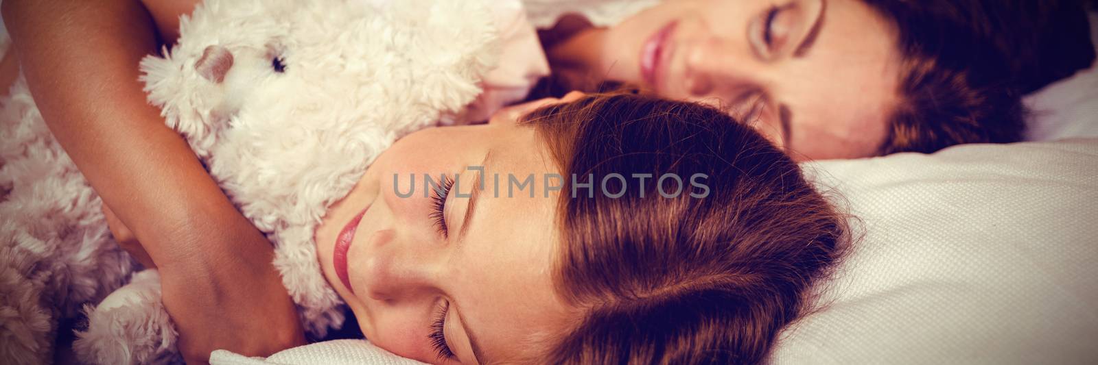 High angle view of family sleeping on bed by Wavebreakmedia