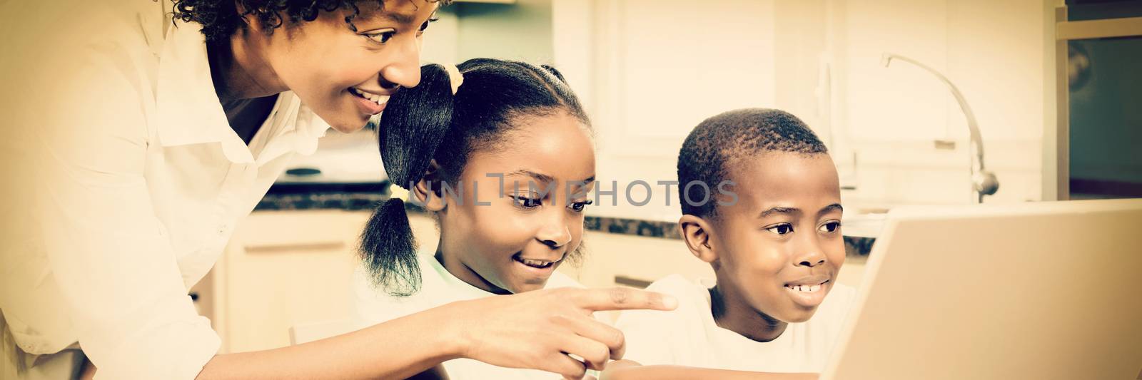 Happy family using laptop in kitchen by Wavebreakmedia