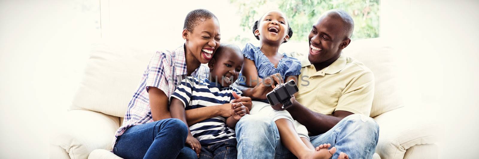 Happy smiling family on couch in living room at home