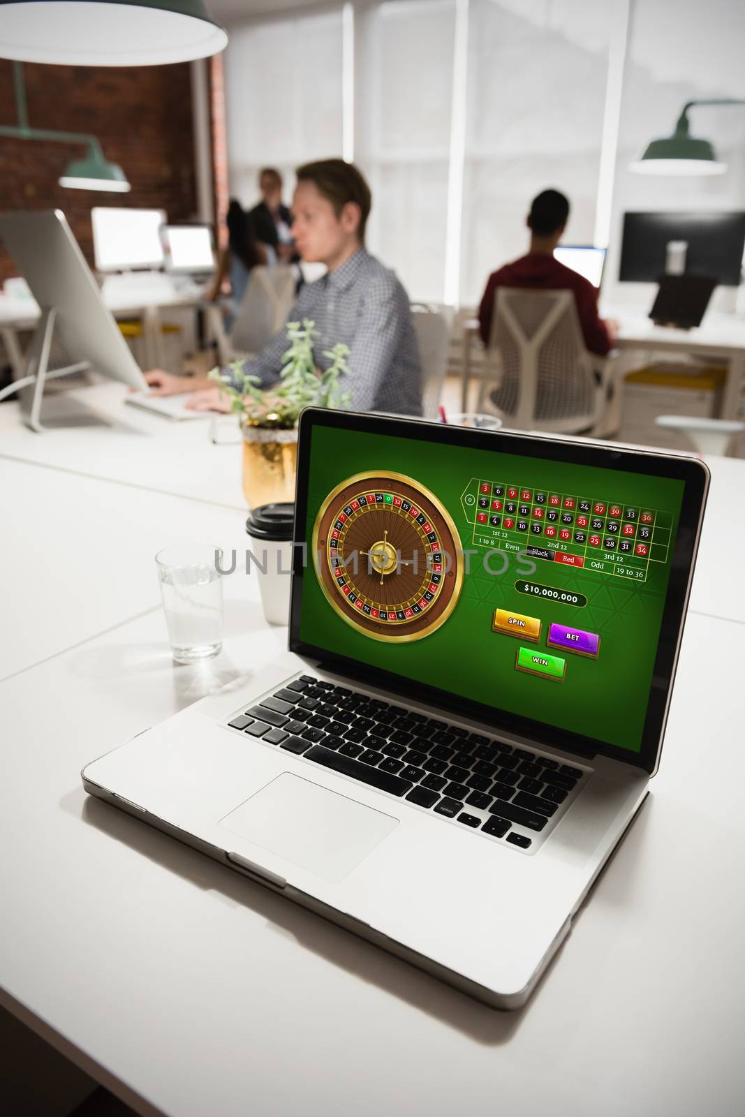 Online Roulette Game  against laptop on table with business people in background