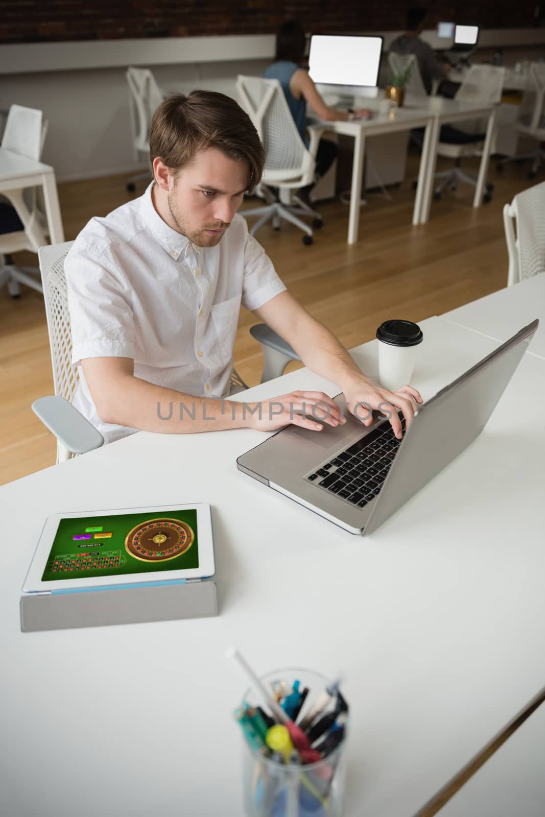 Online Roulette Game  against attentive male executive using laptop at desk