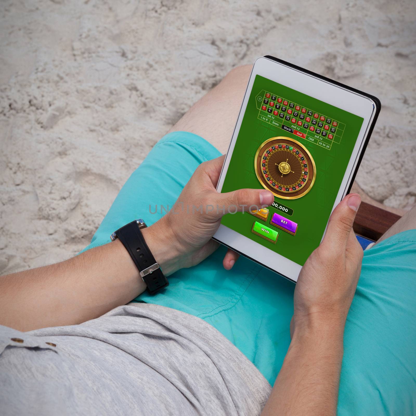 Online Roulette Game  against man using digital tablet on the beach
