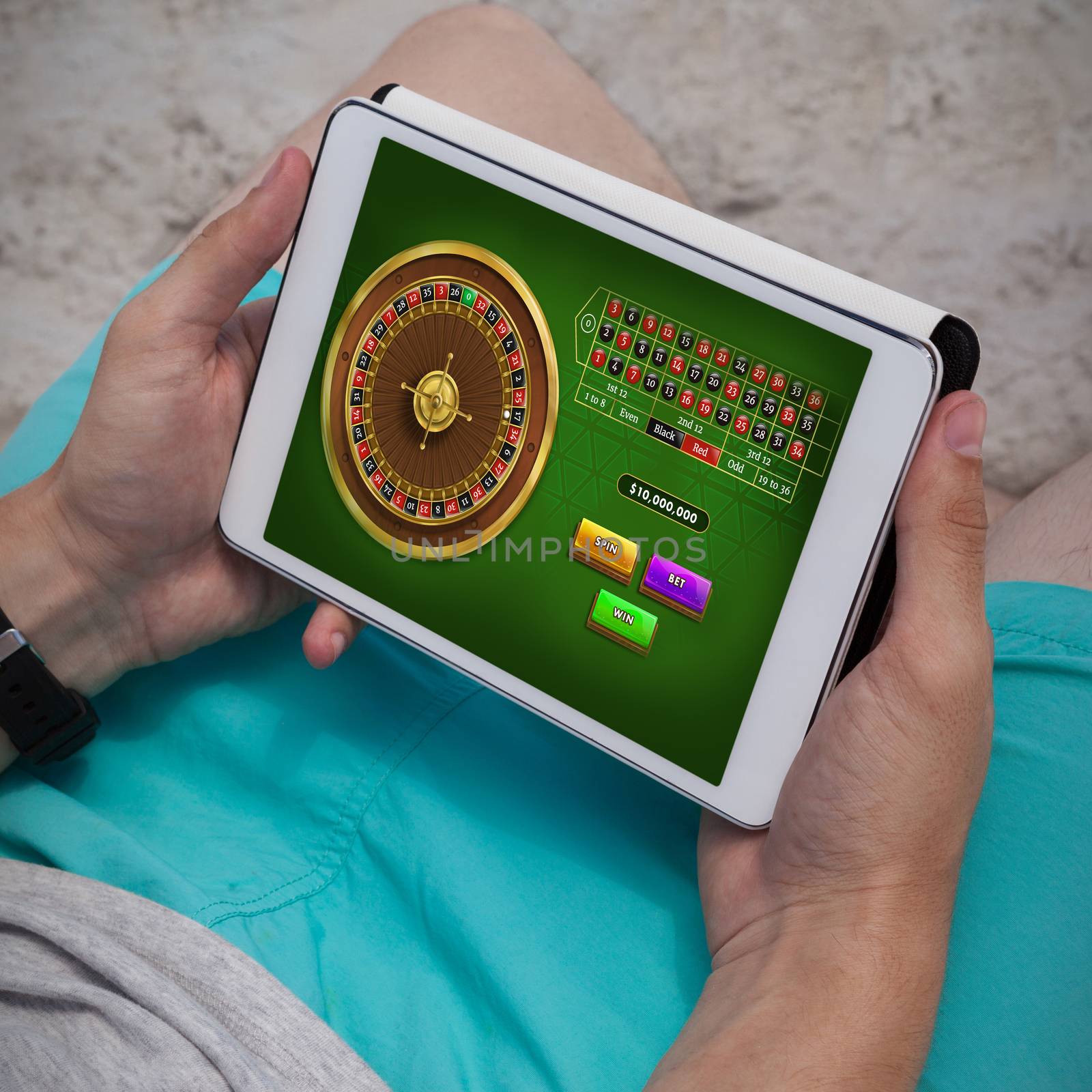 Online Roulette Game  against man using digital tablet on the beach