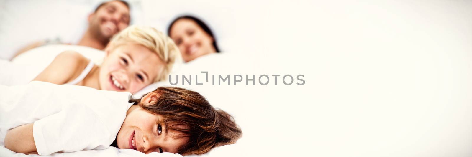 Young family resting together in parent s bed 