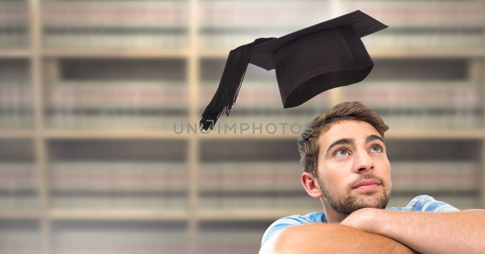 Student man in education library with graduation hat by Wavebreakmedia