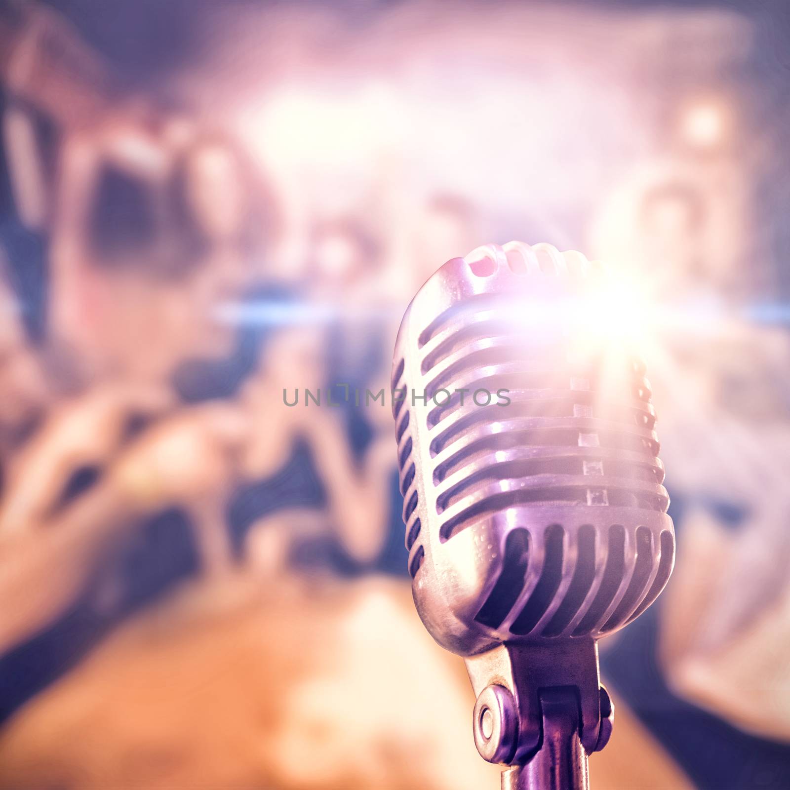 Close-up of microphone  against cheerful friends toasting drinks while performer on stage 