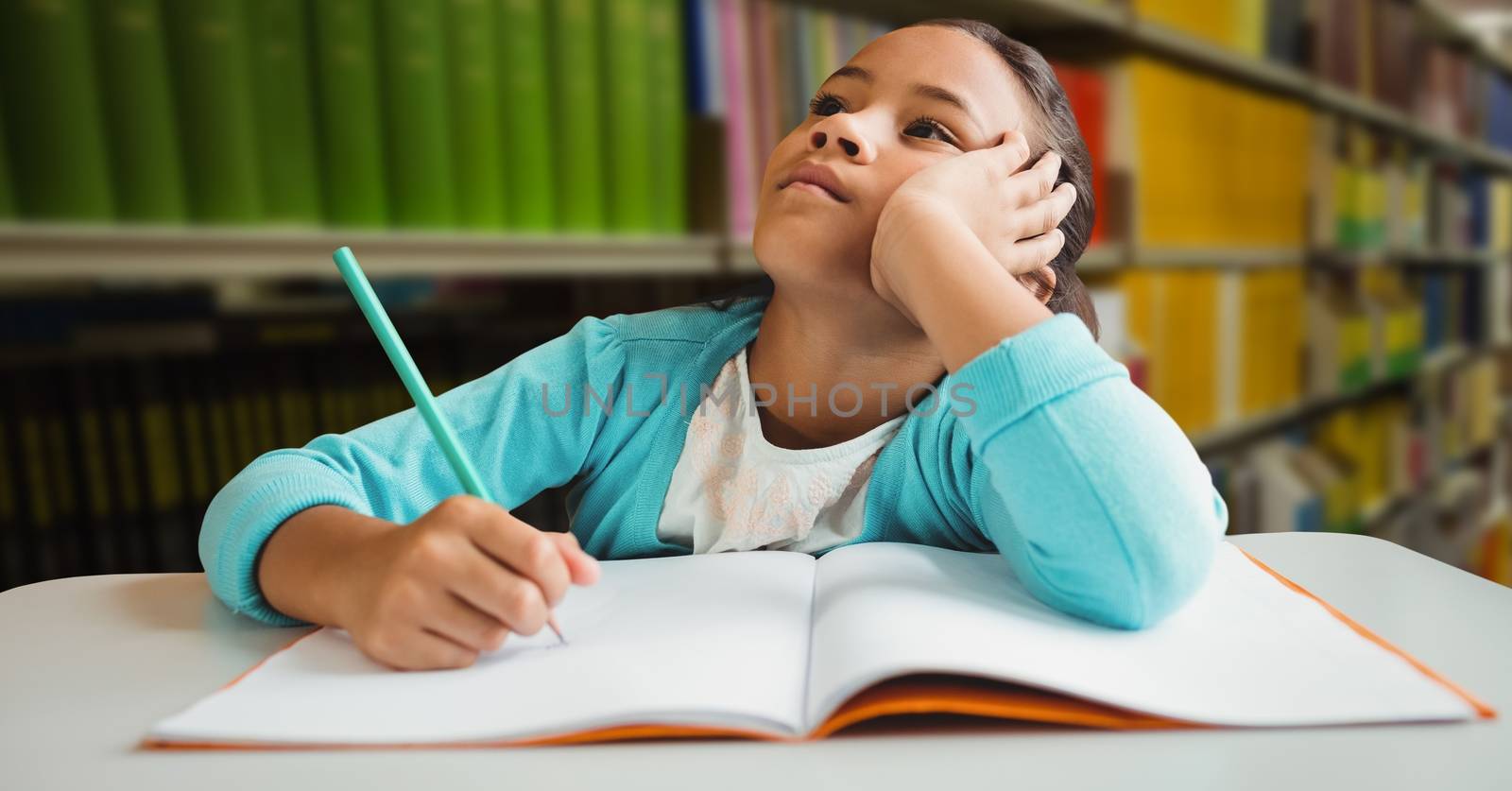 Girl doing schoolwork in education library by Wavebreakmedia