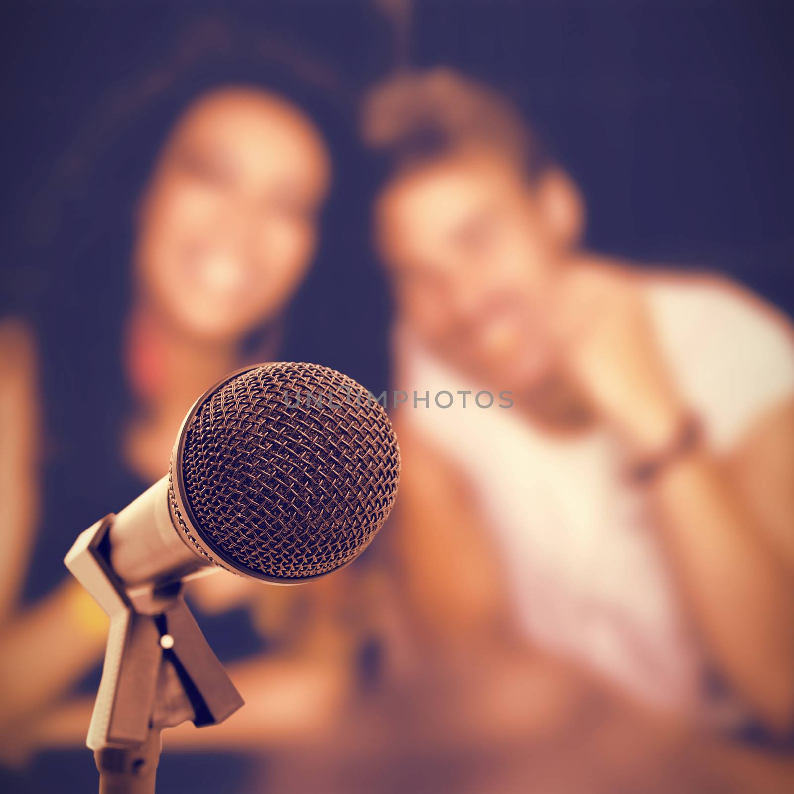 Microphone with stand against smiling friends with beer mugs at nightclub