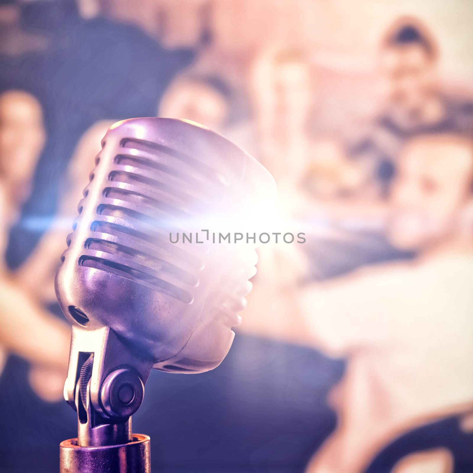 Close-up of microphone  against smiling friends toasting drinks at nightclub