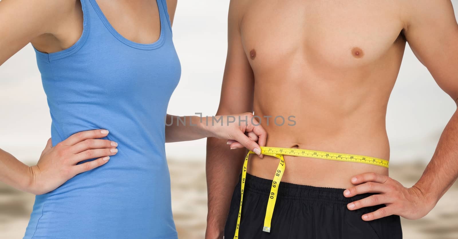 Digital composite of Couple measuring weight with measuring tape on waist on Summer beach