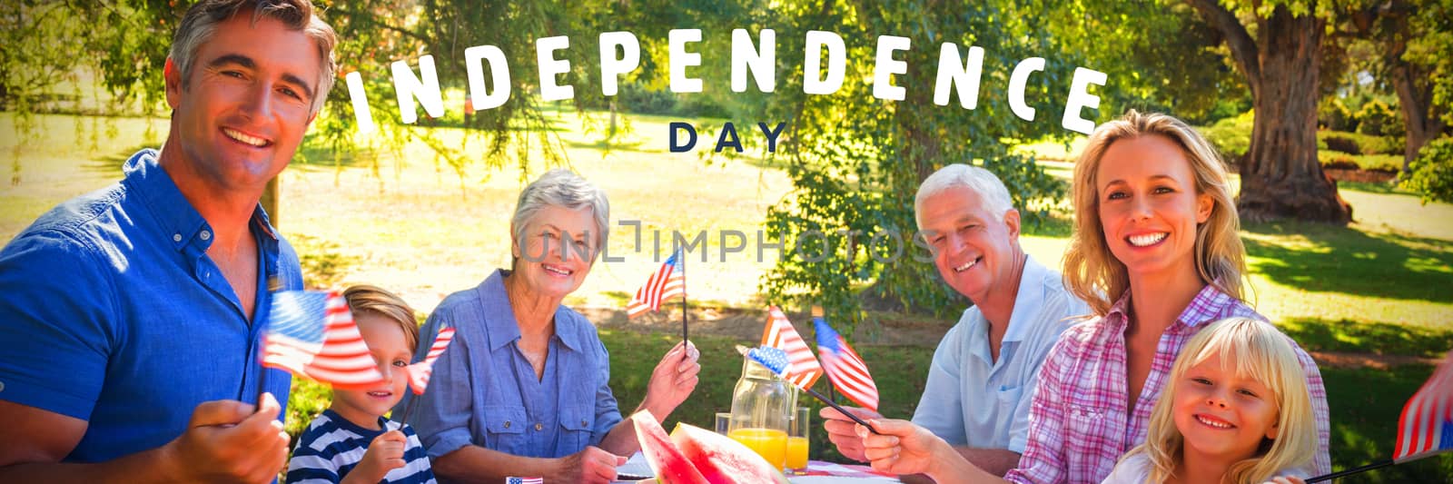 Happy independence day against portrait of family having picnic and holding american flag