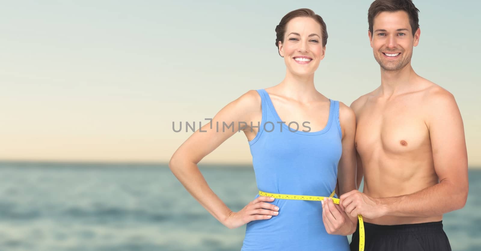 Digital composite of Couple measuring weight with measuring tape on waist on Summer beach