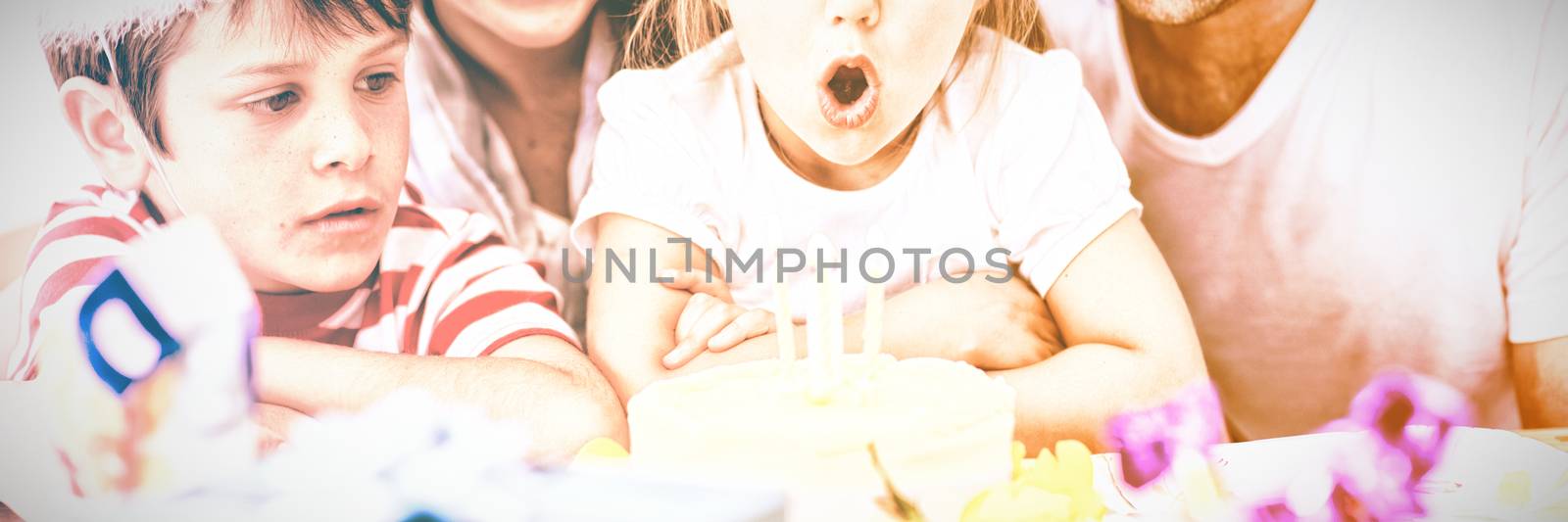 Little girl blowing out candles in her birthday by Wavebreakmedia