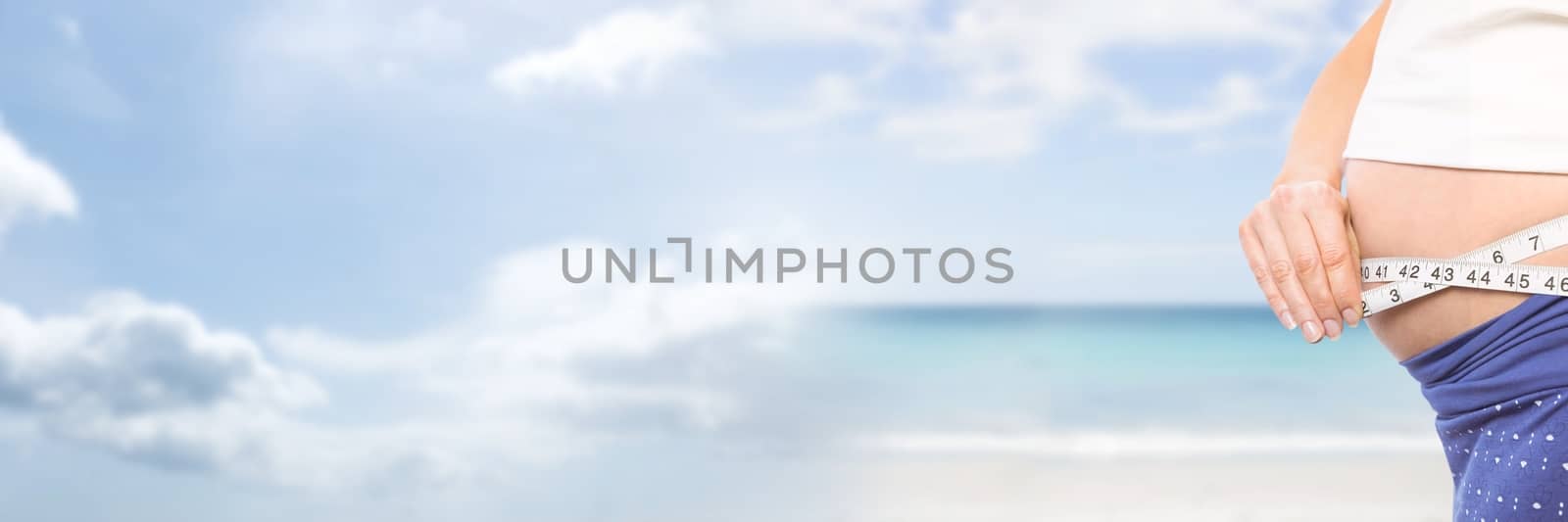 Woman measuring weight with measuring tape on waist on Summer beach with transition by Wavebreakmedia