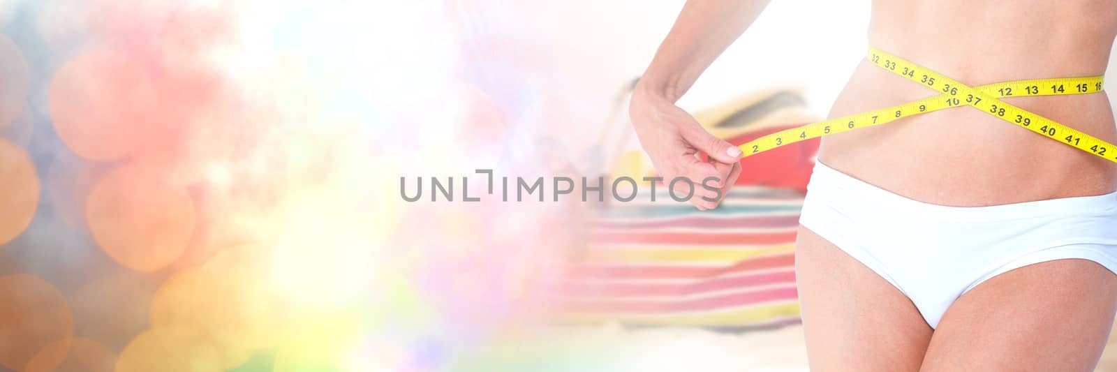 Woman measuring weight with measuring tape on waist on Summer beach with transition by Wavebreakmedia