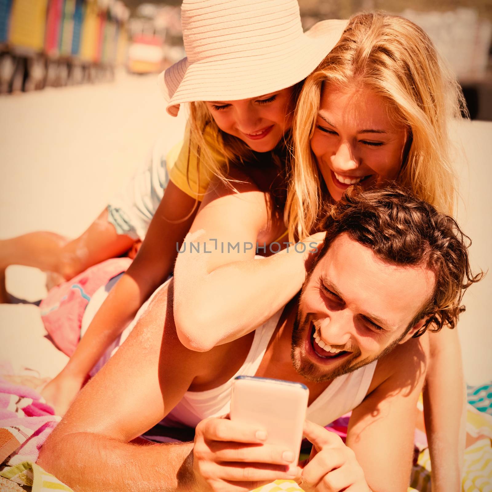 Happy family taking selfie while lying on picnic blanket at beach by Wavebreakmedia