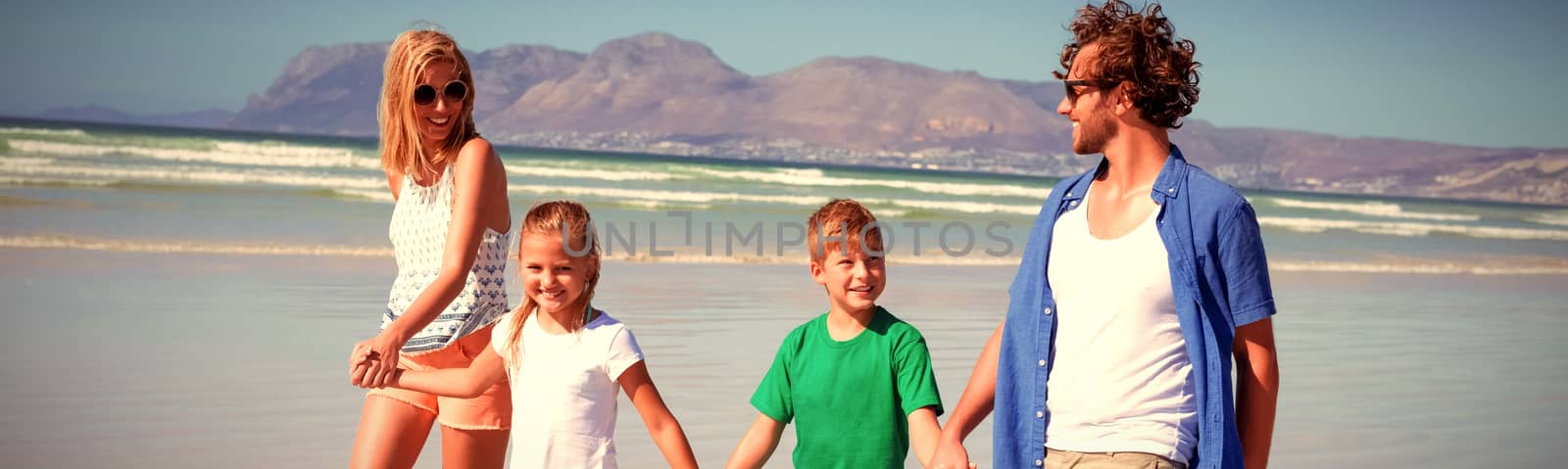 Happy family holding hands while walking at beach by Wavebreakmedia