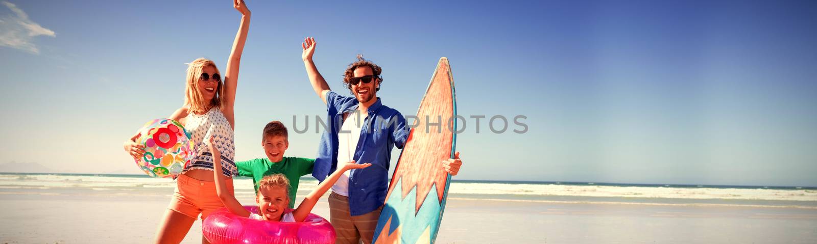 Cheerful family with arms raised at beach by Wavebreakmedia