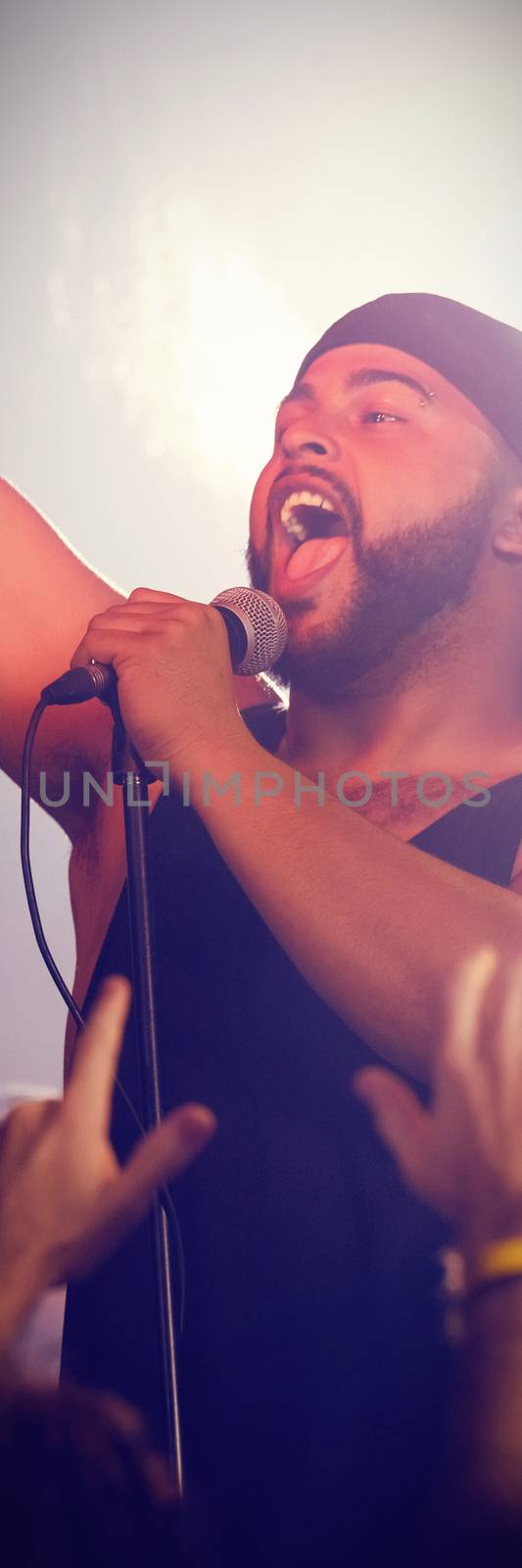 Enthusiastic male singer performing at nightclub during concert