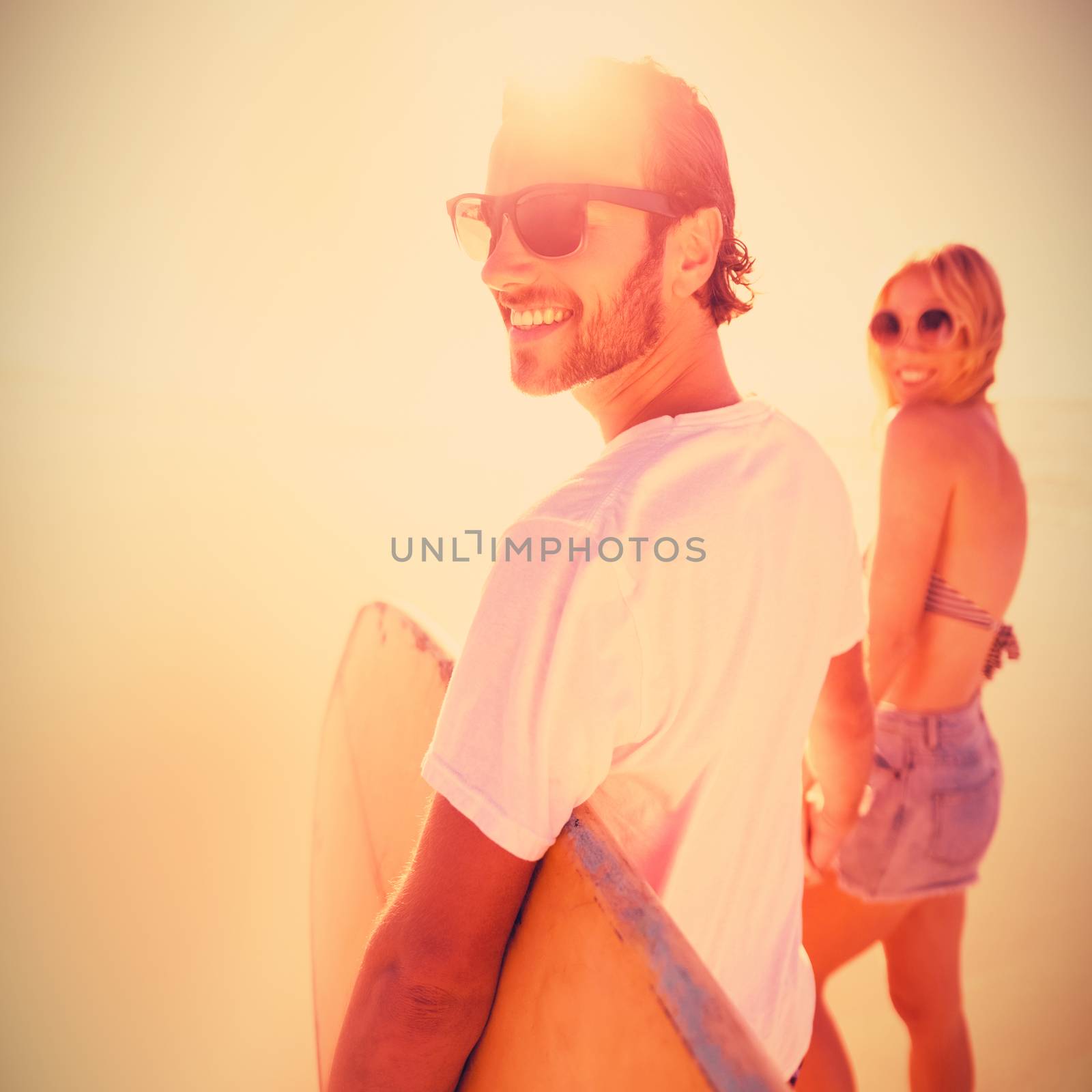 Happy young couple holding hands at beach by Wavebreakmedia