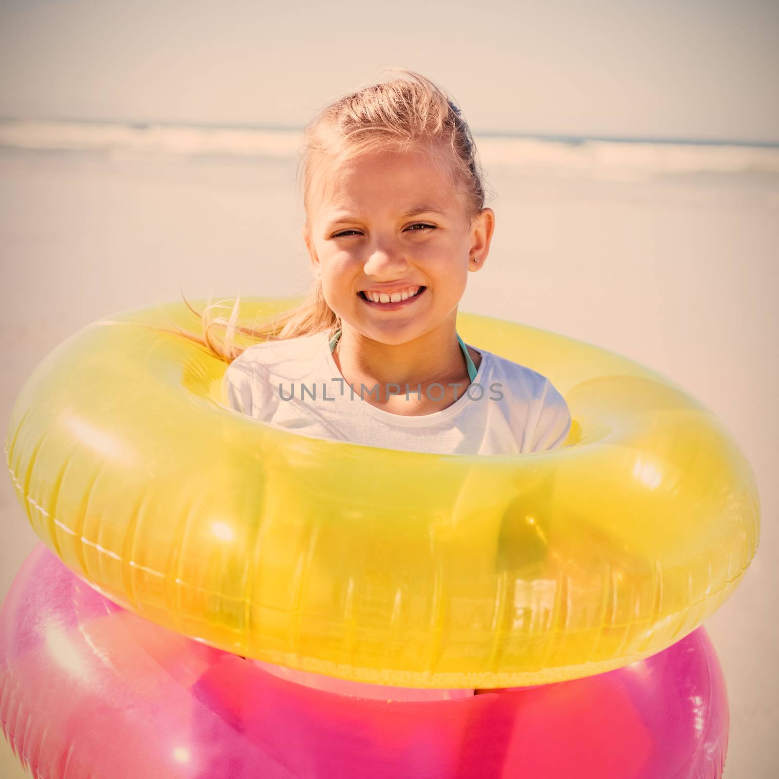 Portrait of girl standing in inflatable rings by Wavebreakmedia