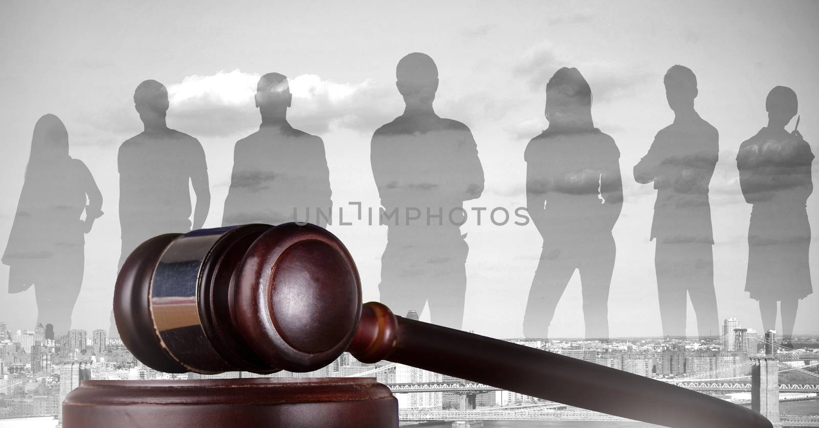 Digital composite of Gavel and people silhouettes over city