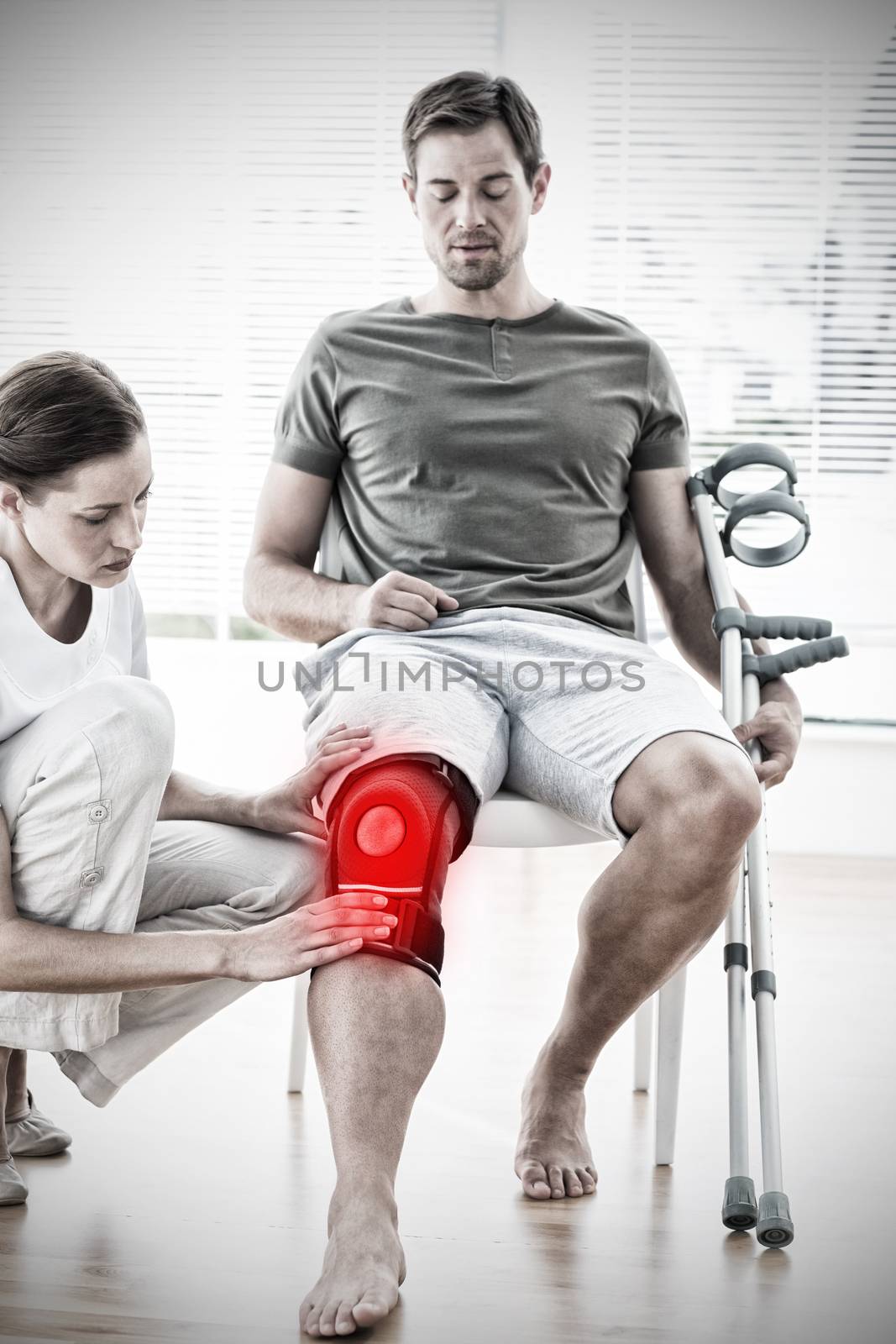 Physiotherapist examining man with crutches against highlighted pain