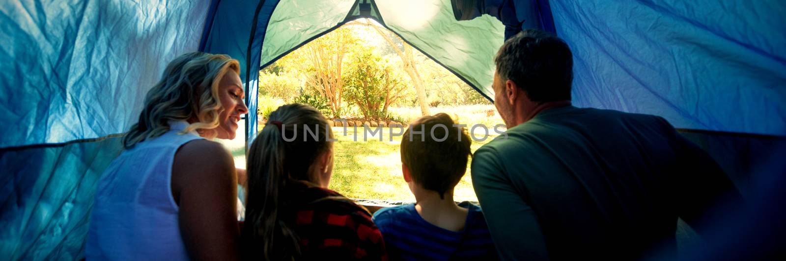 Rear view of family sitting in the tent