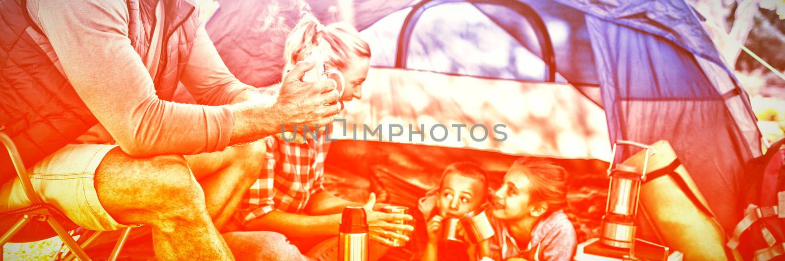 Family having snacks and coffee outside the tent at campsite by Wavebreakmedia