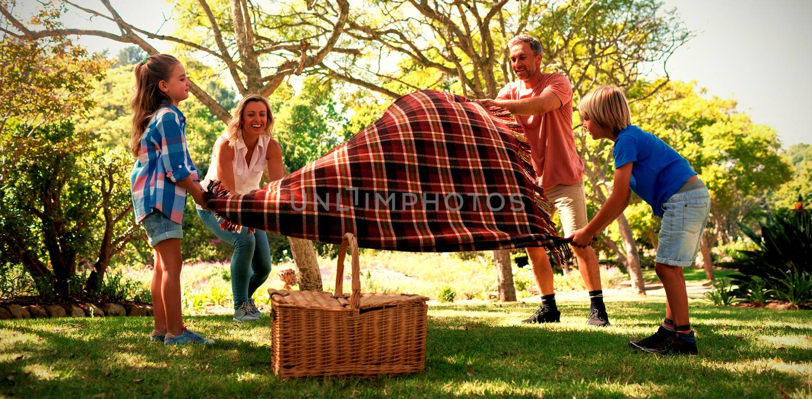 Family spreading the picnic blanket by Wavebreakmedia