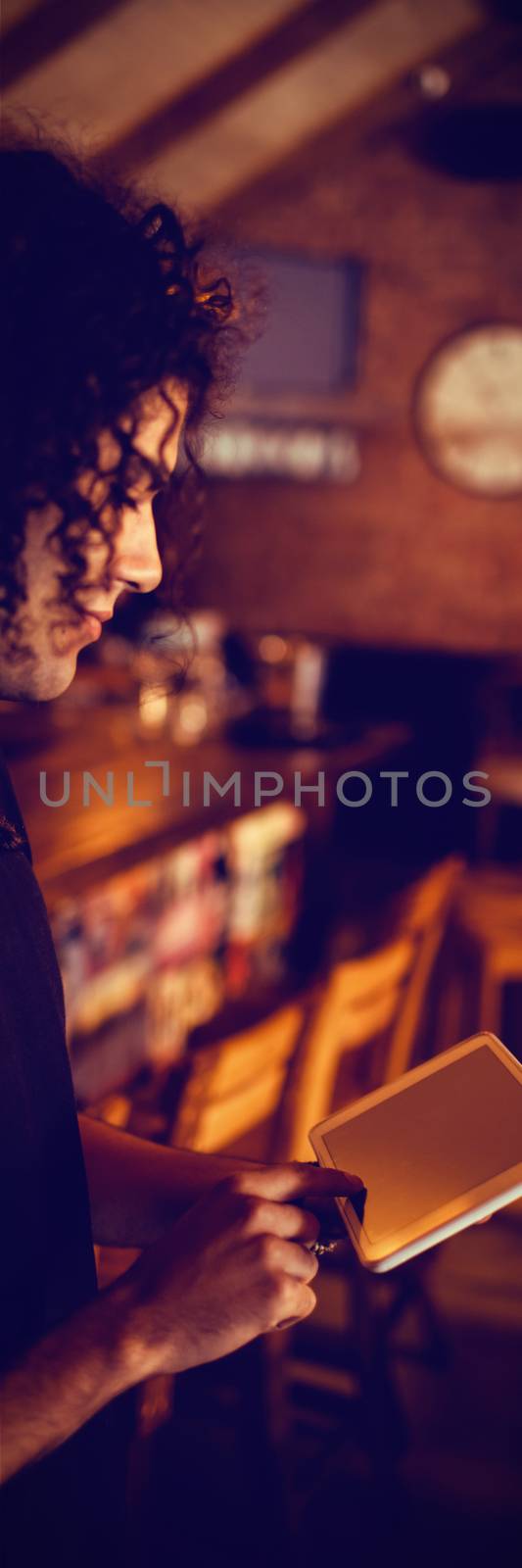 Young man using digital tablet in pub