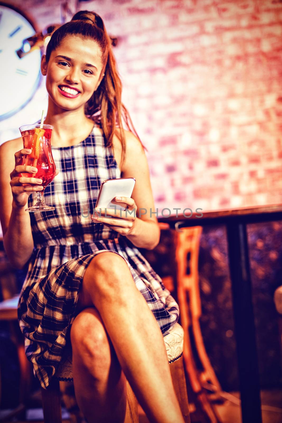 Portrait of two young women having cocktail drinks in pub